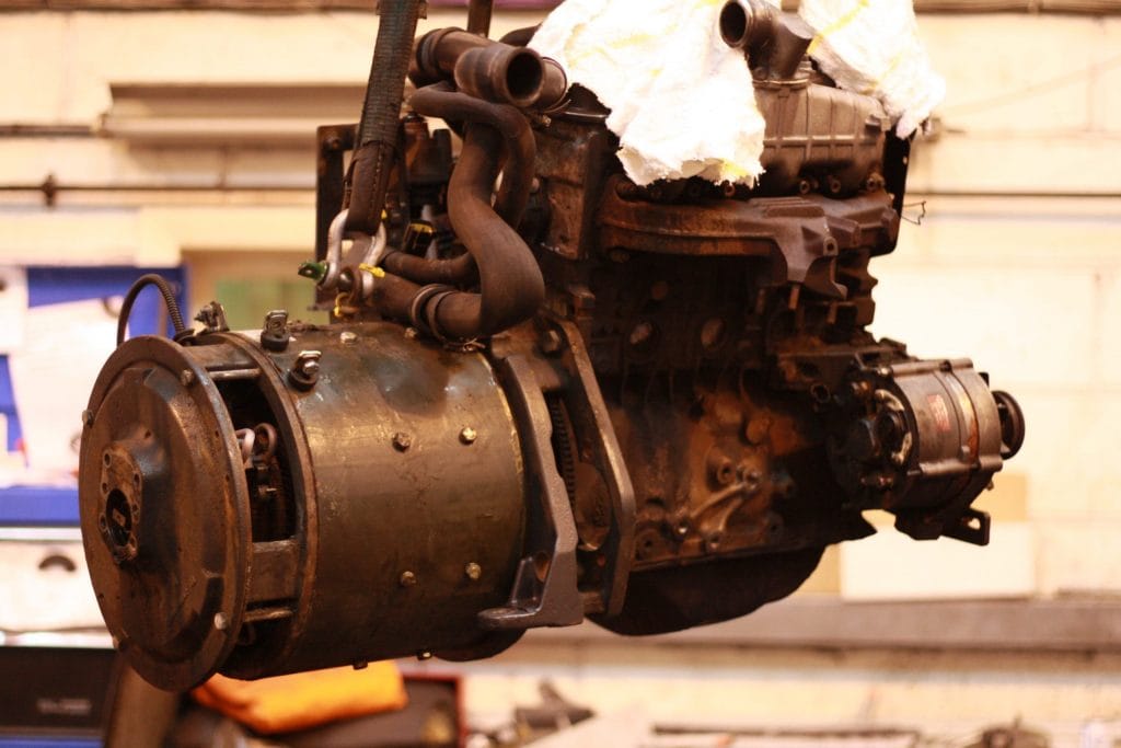 Forklift engine and transmission unit lifted out on a hoist in an Acclaim Handling workshop during a major repair