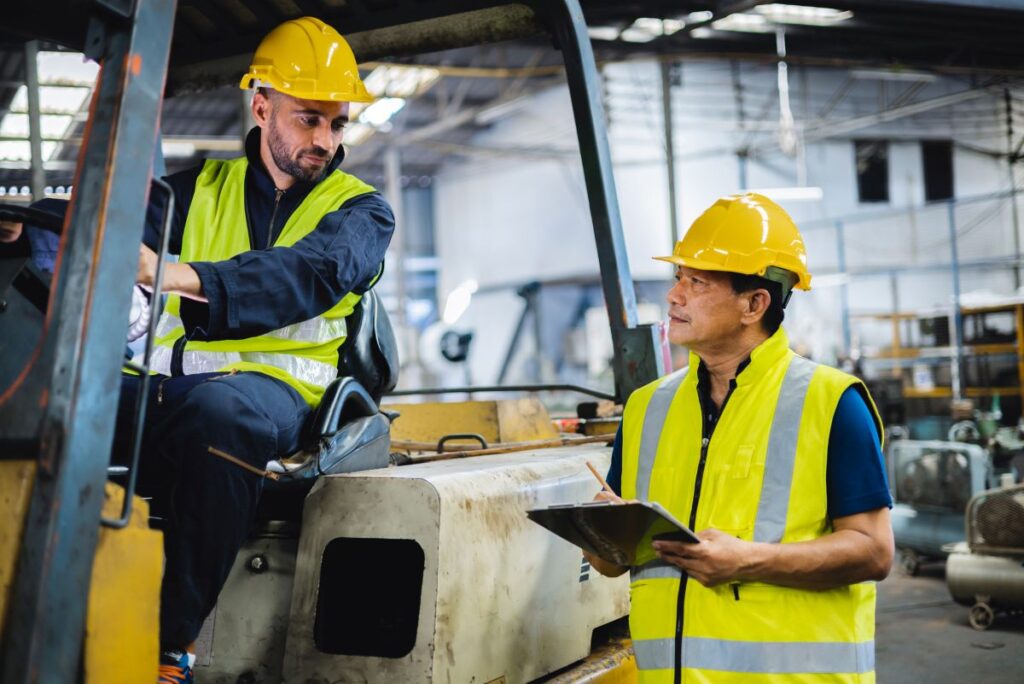 forklift driver speaking to a warehouse supervisor