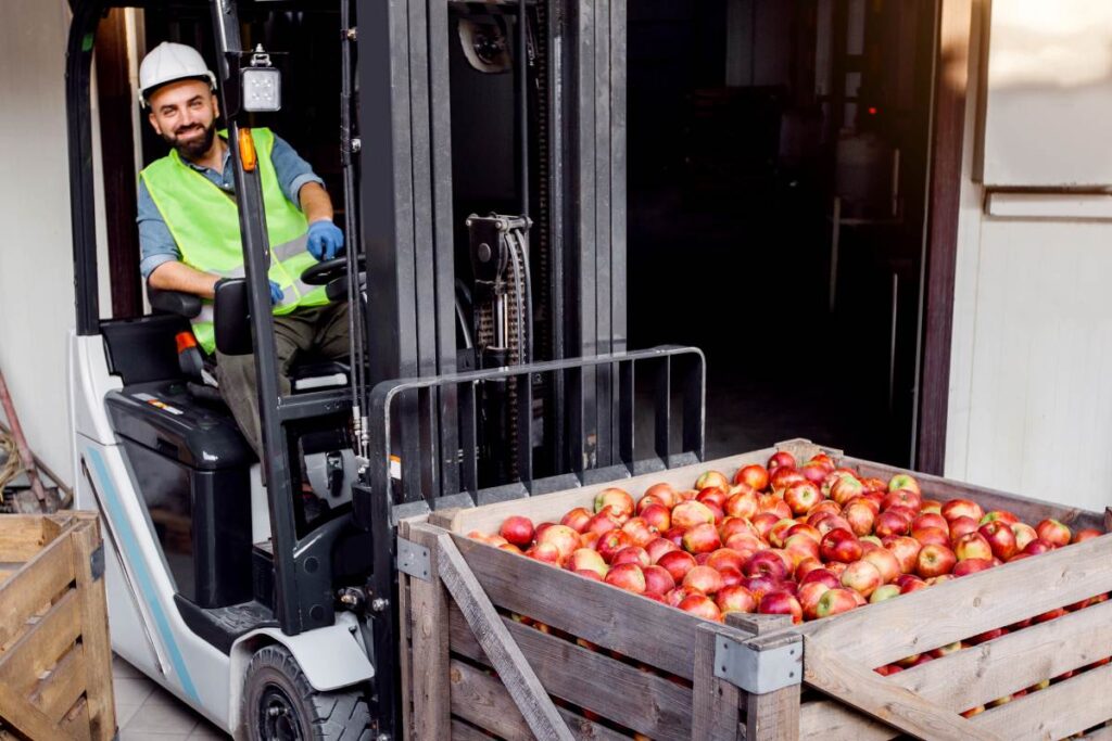 bearded man in hard hat drives forklift truck
